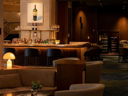 a bar in a restaurant with a counter and chairs at The New Hotel Kumamoto -DLIGHT LIFE & HOTELS- in Kumamoto