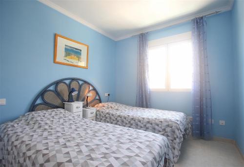 twee bedden in een slaapkamer met blauwe muren en een raam bij Apartamento Casa Stella con piscina by costablancarent in Denia