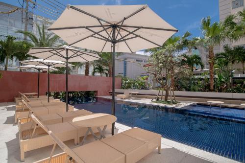 a pool with chairs and umbrellas next to a pool at Hotel Palm Royal Resort Kokusai Street in Naha