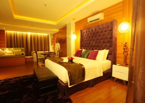 1 dormitorio con 1 cama grande y sala de estar en Royal Asnof Hotel Pekanbaru en Pekanbaru
