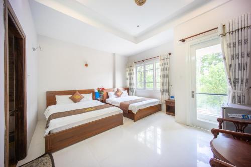 a bedroom with two beds and a window at My Kim Guest House in Da Lat