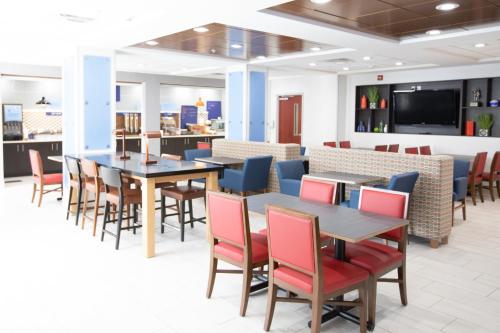 a dining room with tables and chairs and a tv at Holiday Inn Express & Suites Knoxville-Farragut by IHG in Knoxville