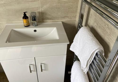 a bathroom with a white sink and white towels at Rowley Farm Holidays in Worcester