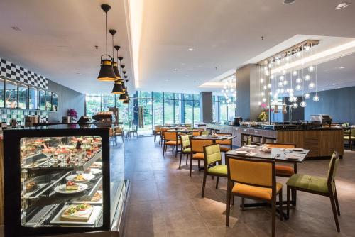 a restaurant with tables and chairs and a buffet at Geno Hotel Shah Alam in Shah Alam