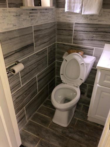 a bathroom with a toilet and a toilet paper roll at Skyview Motor Inn in Johnston