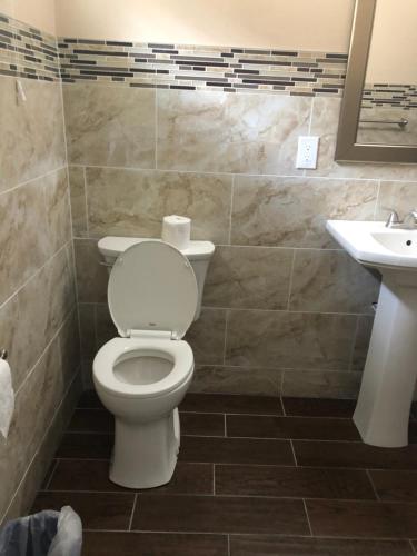 a bathroom with a toilet and a sink at Skyview Motor Inn in Johnston