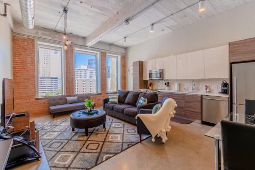 a large living room with a couch and a kitchen at GA Living Suites- Downtown Dallas Corporate Suites in Dallas