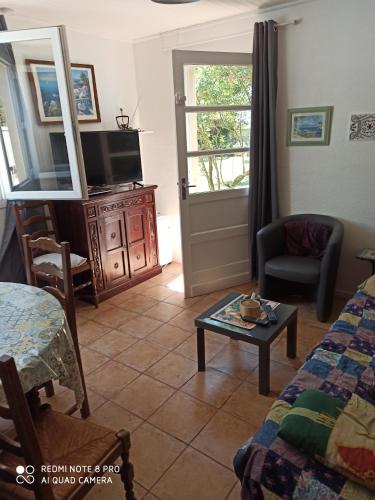 un salon avec un canapé, une télévision et une table dans l'établissement gite de France, à Saint-Cyprien