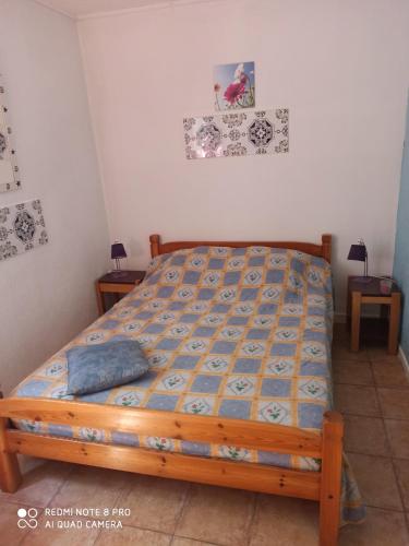 - une chambre avec un lit doté d'une couverture bleue dans l'établissement gite de France, à Saint-Cyprien