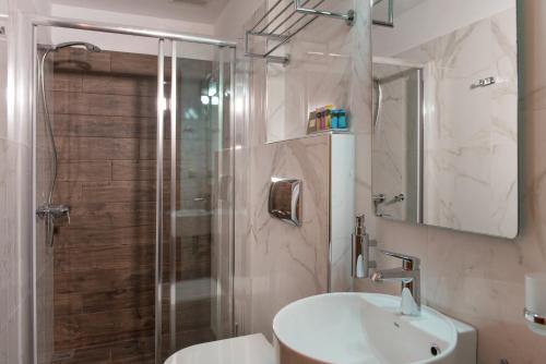 ein Bad mit einer Dusche, einem Waschbecken und einem WC in der Unterkunft Konaki Ouranoupolis in Ouranoupoli