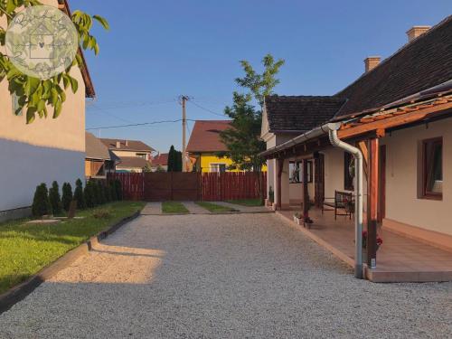 a driveway leading to a house with a porch at Borbély Vendégház in Nagykanizsa