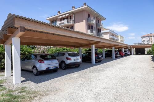 a parking lot with cars parked in front of a building at Hotel Primavera sul mare in Lido di Savio