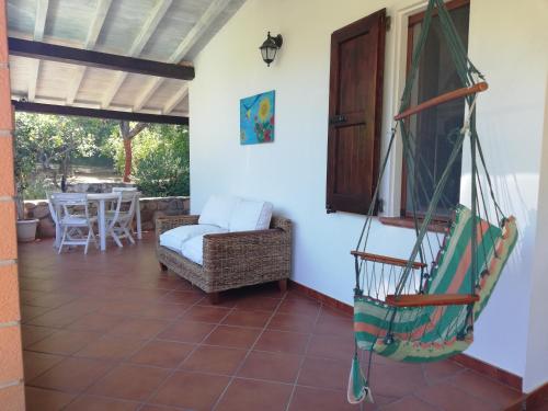 a room with a porch with a chair and a table at Villa REBECCA in Solanas