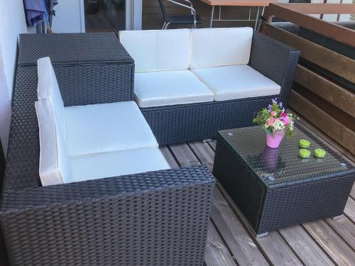 two wicker chairs and a table on a patio at HAKs Alpine Studio Cozy Retreat Leukerbad in Leukerbad