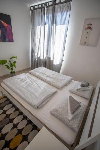 a white bed with white sheets and towels on it at Apartment in the City Center in Innsbruck