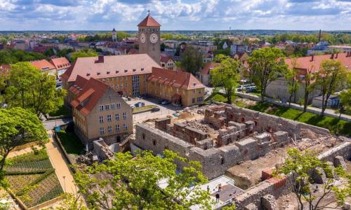 an old building with a clock tower in a city at Apartamenty Oleńka II - Szczytno Mazury in Szczytno