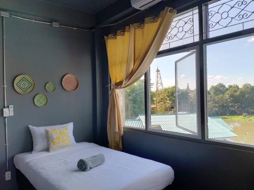a bedroom with two beds and a large window at Tharuadaeng Old city Ayutthaya ท่าเรือแดง กรุงเก่า อยุธยา in Phra Nakhon Si Ayutthaya