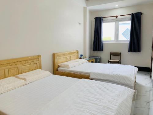 a bedroom with two beds and a window at PHUONG QUYEN hotel in Cu Lao Thu