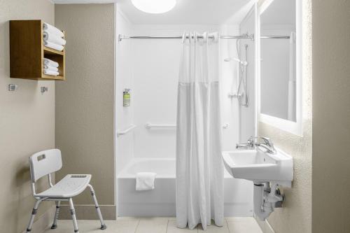 a bathroom with a shower and a sink and a chair at Staybridge Suites Chattanooga-Hamilton Place by IHG in Chattanooga