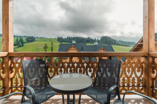 a table and chairs on a balcony with a view at Zakątek Homole in Jaworki
