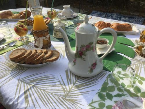 a table with a tea kettle and bread on it at Ô fil de L'ô in Clairac