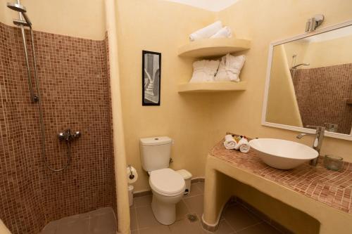 a bathroom with a toilet and a sink and a shower at Iatis View Collection in Imerovigli