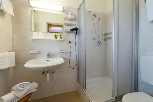 a bathroom with a shower and a sink and a toilet at Hotel Pension Rechtenthal in Termeno