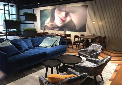 a living room with a blue couch and chairs at Original Sokos Hotel Lappee in Lappeenranta