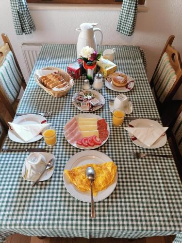 een tafel met ontbijtproducten op een geruite tafeldoek bij House Jezerka in Jezerce