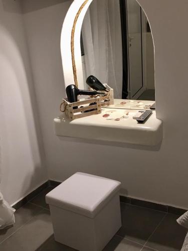 a bathroom with a toilet and a mirror at Kampanelia Village Suites in Fira