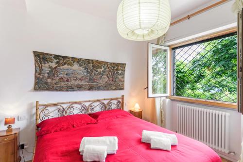 a bedroom with a red bed with two white towels on it at Como Lake Cosy Flat with Garden and Parking in Cernobbio