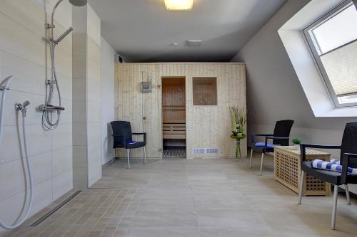 an attic bathroom with a shower and chairs at Lindenhof in Osterspai