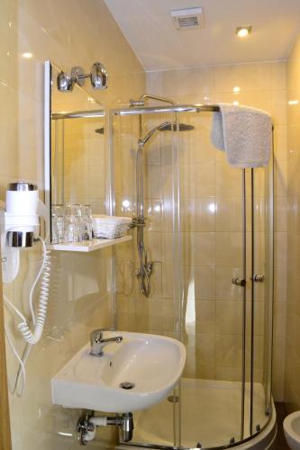 La salle de bains est pourvue d'un lavabo et d'une douche. dans l'établissement Comfort-24, à Słupca