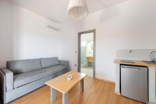 a living room with a couch and a table at Aegean Paradiso Vacation Club - "Adults Only" in Azolimnos