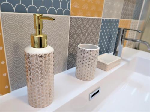 La salle de bains est pourvue d'un lavabo avec un robinet et un lavabo. dans l'établissement Appart'Confort - Le Trégor, à Lannion