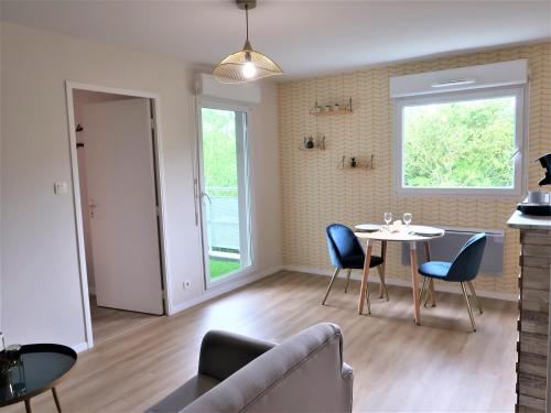 un salon avec une table et des chaises et une fenêtre dans l'établissement Appart'Confort - Le Trégor, à Lannion