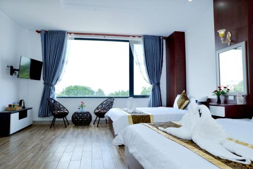 a hotel room with two beds and a large window at Buon Ma Thuot Hotel in Buon Ma Thuot