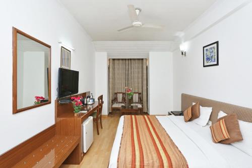 a hotel room with a bed and a mirror at Hotel Windsor Castle Cyber City in Gurgaon