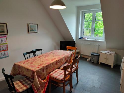 a dining room with a table and chairs and a window at Forsthof Schlemmin in Eickhof
