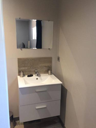 une salle de bain avec un lavabo blanc et un miroir dans l'établissement Chambre indépendante 25 m2 au calme avec piscine et terrain de pétanque, à Lieuran-lès-Béziers