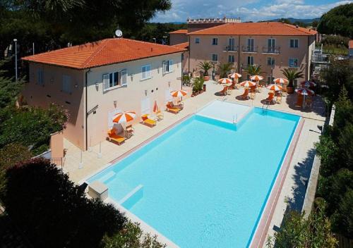 widok na basen z leżakami i parasolami w obiekcie Bolgheri Marina Resort w mieście Marina di Bibbona
