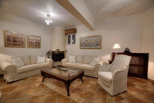 a living room with two couches and a coffee table at Lagonisi Villa VIP in Lagonissi