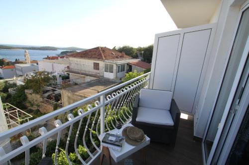 a balcony with a chair and a view of the ocean at Tanya-Apartments and Rooms in Hvar