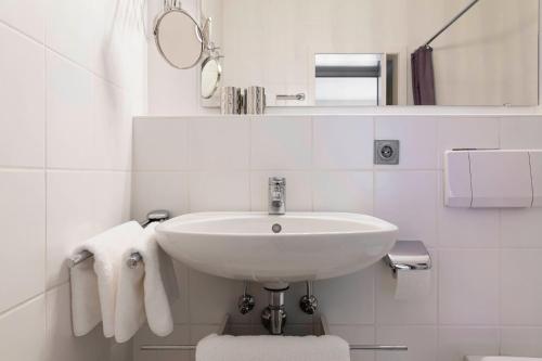 a white bathroom with a sink and towels at Ferienwohnung Sabolowitsch in Lam