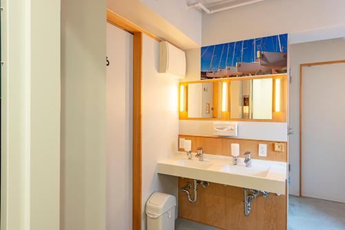 La salle de bains est pourvue d'un lavabo, de toilettes et d'un miroir. dans l'établissement plat hostel keikyu asakusa station, à Tokyo