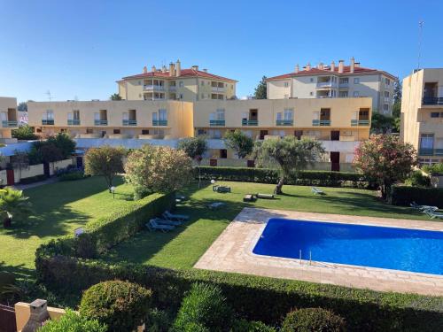an apartment with a swimming pool in front of a building at Barca do Lago - Vilamoura in Vilamoura