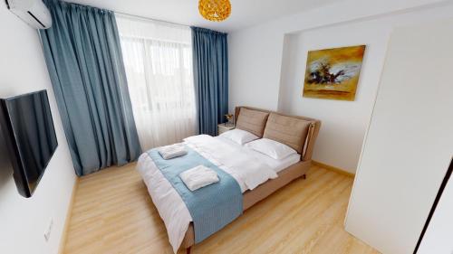 a bedroom with a bed with blue curtains at Le Blanc ApartHotel in Bucharest