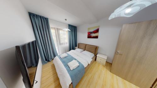 a small bedroom with a bed and a window at Le Blanc ApartHotel in Bucharest