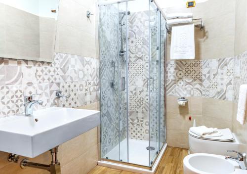 a bathroom with a shower and a sink and a toilet at Belsito Hotel in Nola