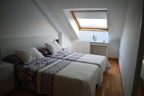 een kleine slaapkamer met een bed en een raam bij Apartamento Aldara a escasos metros de la playa in Samieira